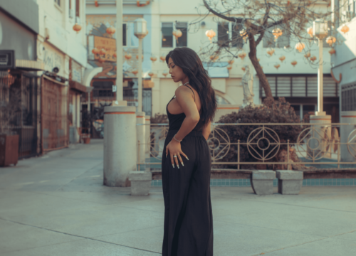 Woman in a black dress standing in a city square